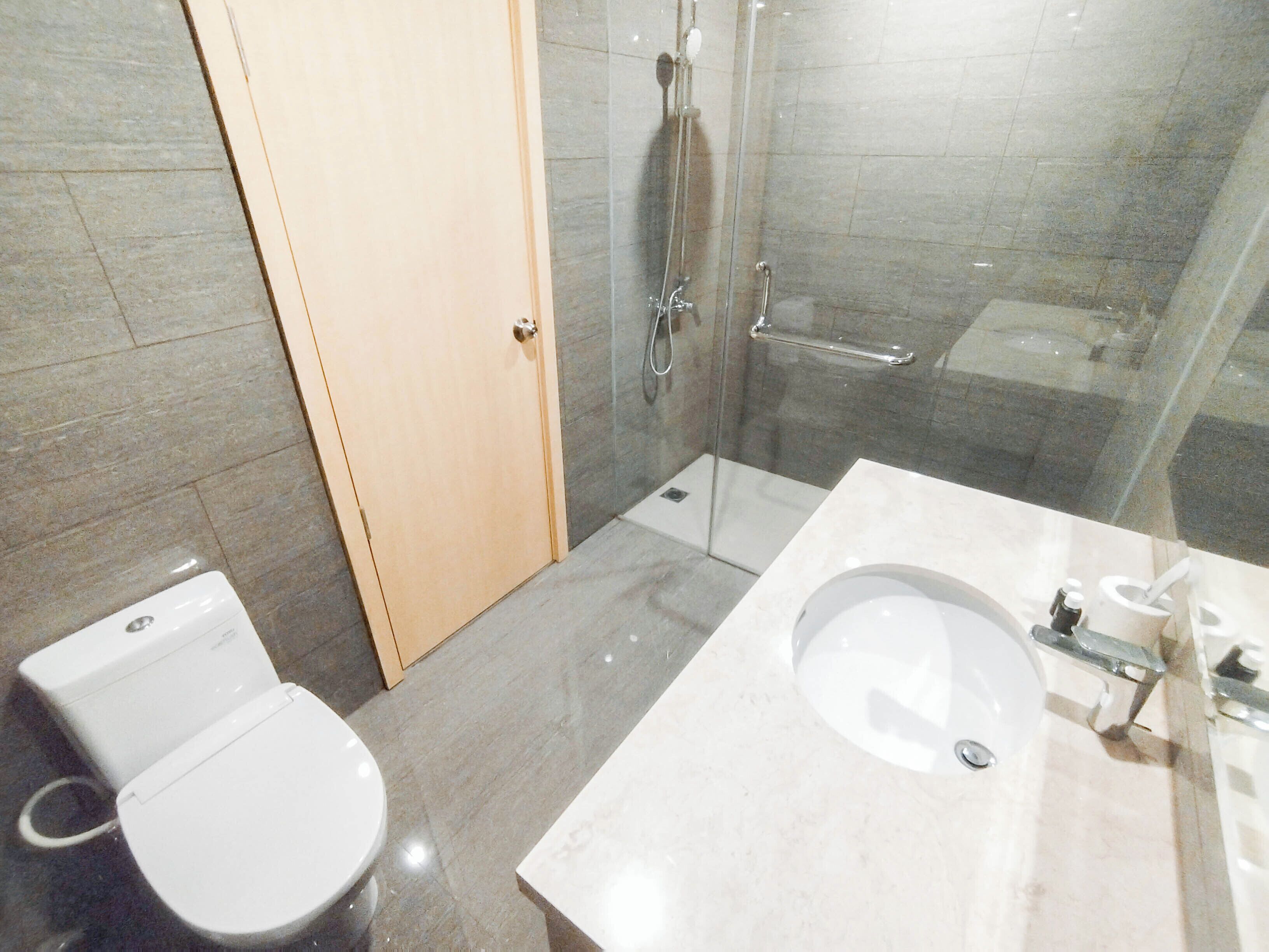 Een badkamer met toilet, wastafel en douche.