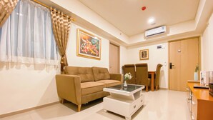 A living room with a sofa, coffee table, and a dining area with chairs and a table.