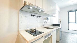 A modern kitchen with a built-in stove, a stainless steel range hood, and a window providing natural light.