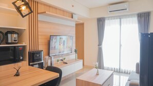 Una sala de estar moderna con un televisor de pantalla plana, muebles de madera, una cafetera y un ventanal con cortinas.