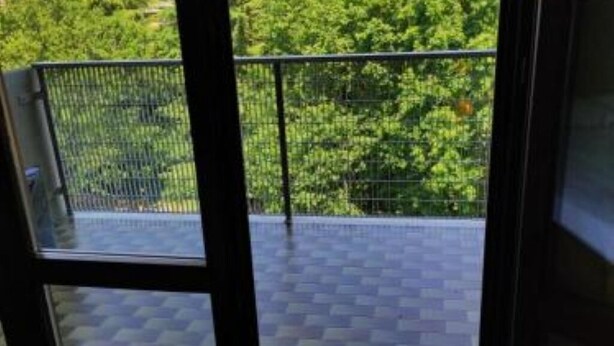 A balcony with a metal railing and a view of green trees. - Two-room apartment Padua strategic area bookable minimum 7 nights max 20 nights. (Padova)