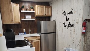 Una cocina moderna con armarios de madera, un refrigerador de acero inoxidable y una mesa de comedor blanca.