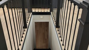 A modern staircase with black railings and a wooden floor. - Secluded Hideaway at Fish & Fiddle Family Resort & Extended Stay (Mountain Home)