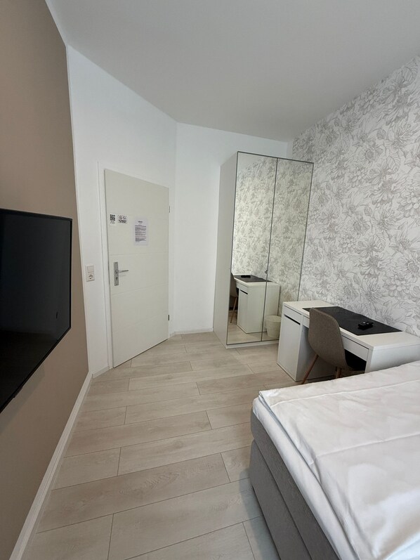 A hotel room with a bed, a desk, a chair, a TV, and a wardrobe. - Hotel Astra (Rheinfelden (Baden))