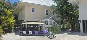 A building with a porch, a wheelchair accessible vehicle, and bicycles. - Sunset Captiva 58. Charming 3-bedroom home in the heart of Captiva village. (captiva)