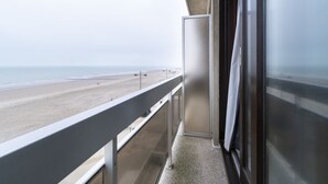 A balcony with a view of a beach and ocean.