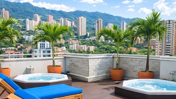 A rooftop terrace with lounge chairs, a hot tub, and potted plants. - Penthouse Apt Poblado, City View, Rooftop Jacuzzis (Medellín)