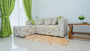 Un salon moderne avec un canapé à motifs floraux, une table basse en bois et un tapis moelleux.