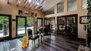 A lobby with a tiled floor, a caution sign, a reception desk, and a view of parked cars outside. - Cobbly Nob Cove #105 (Gatlinburg)