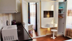 A compact kitchen with a black countertop, a white sink, and a small stool. - IQ Hotel Galatasaray (Istanbul)