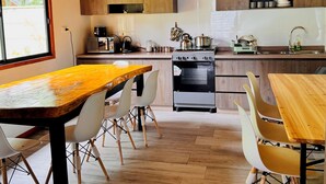 Une cuisine moderne avec des meubles en bois, une grande table à manger et un four encastré.
