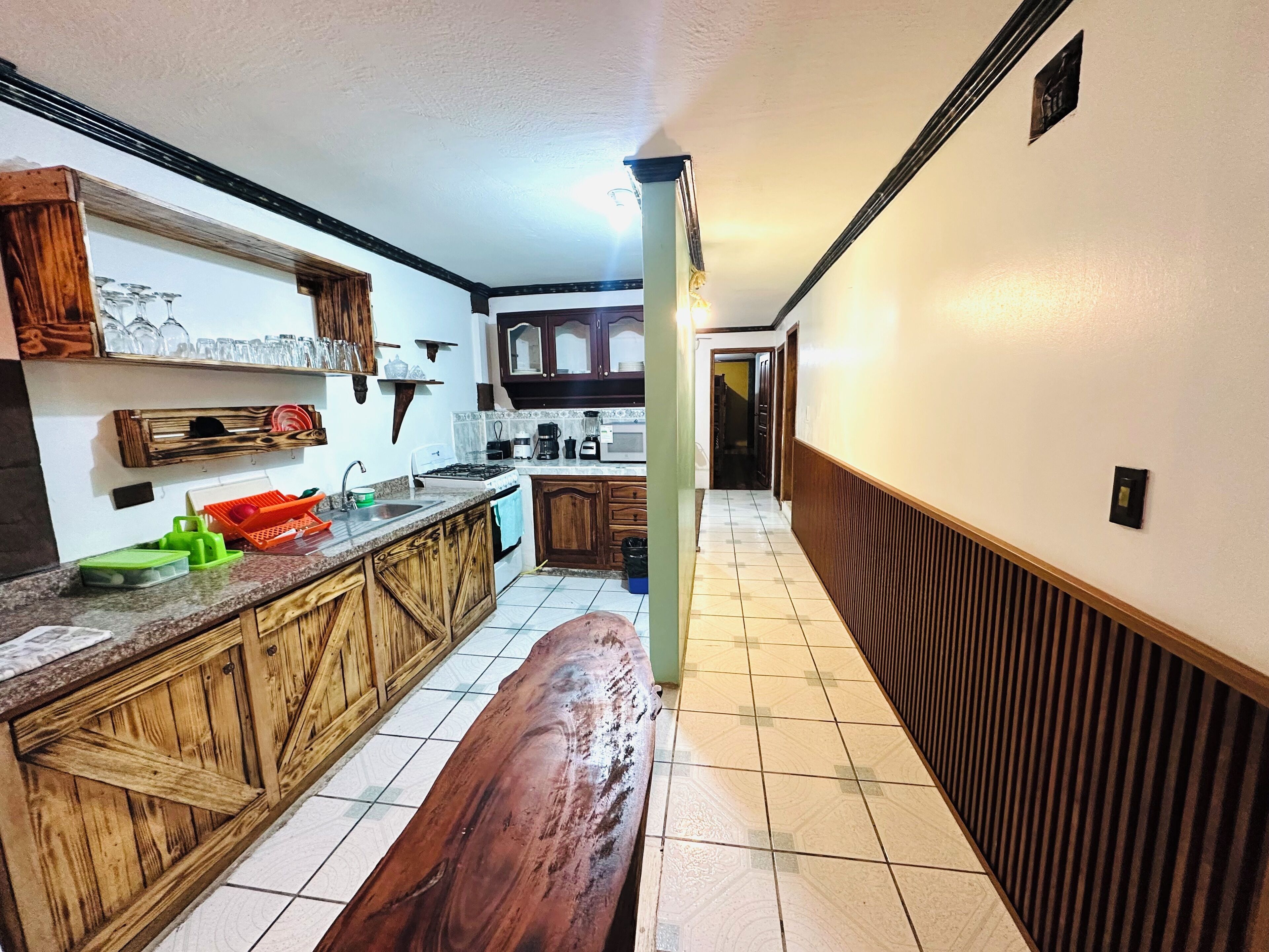 Una cucina con mobili in legno, un piano di lavoro e una panca.