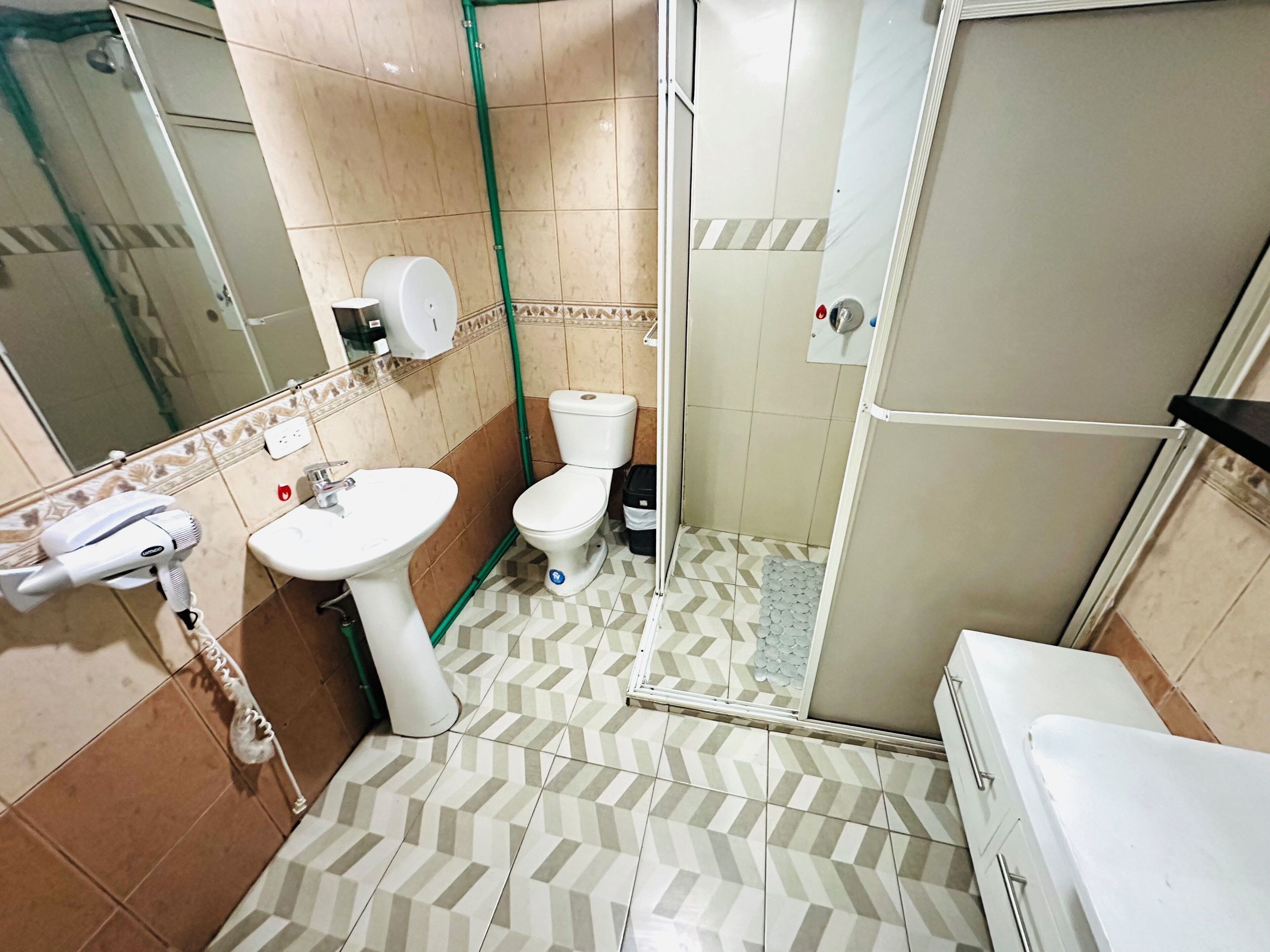 Een badkamer met toilet, wastafel en douche.
