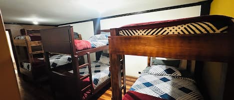 Habitación con literas, cabecera de madera y escalera.