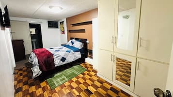 Una camera da letto con un letto, un armadio e un bagno sullo sfondo.