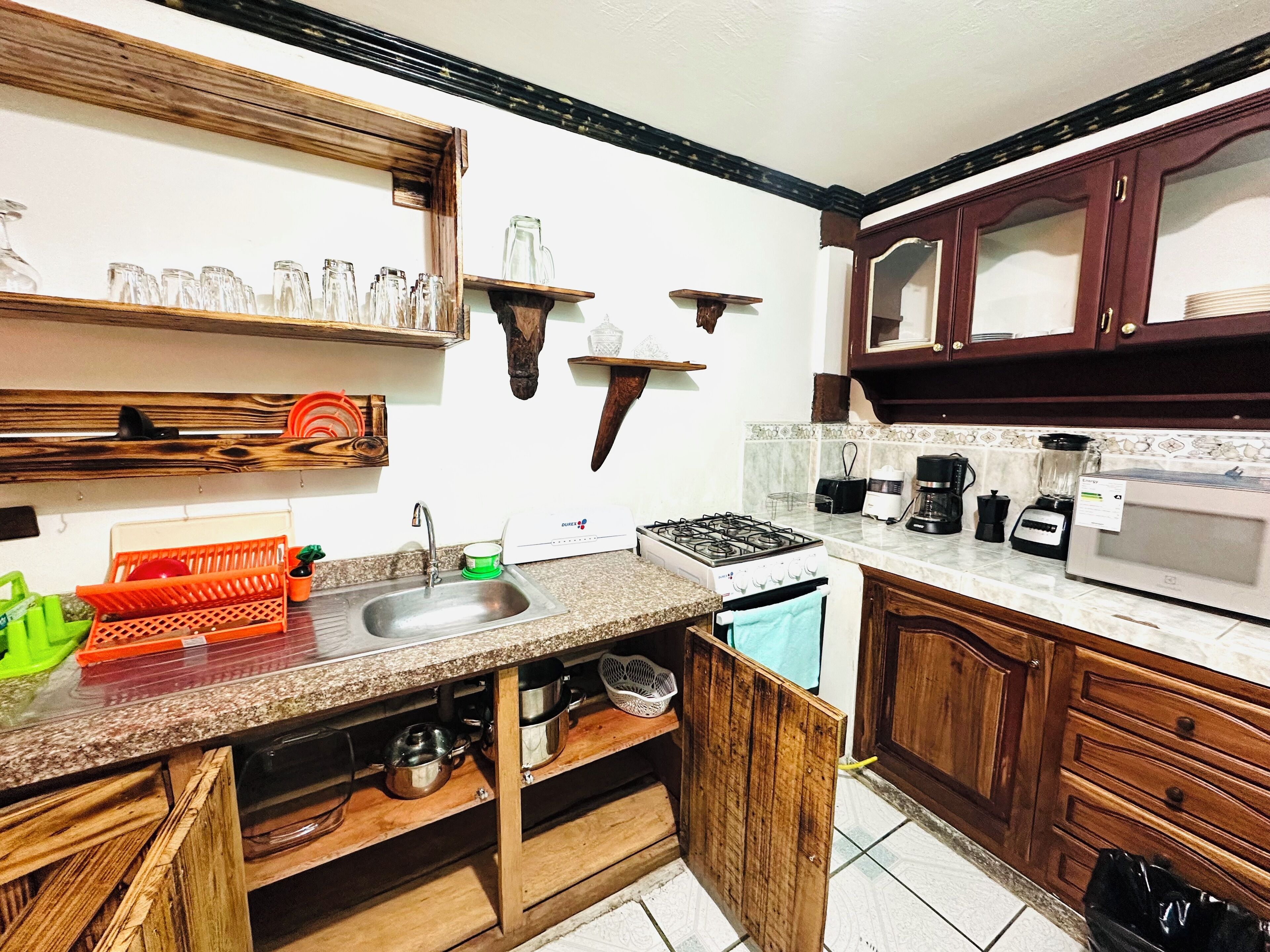 A kitchen with wooden cabinets, a sink, a stove, and various appliances.