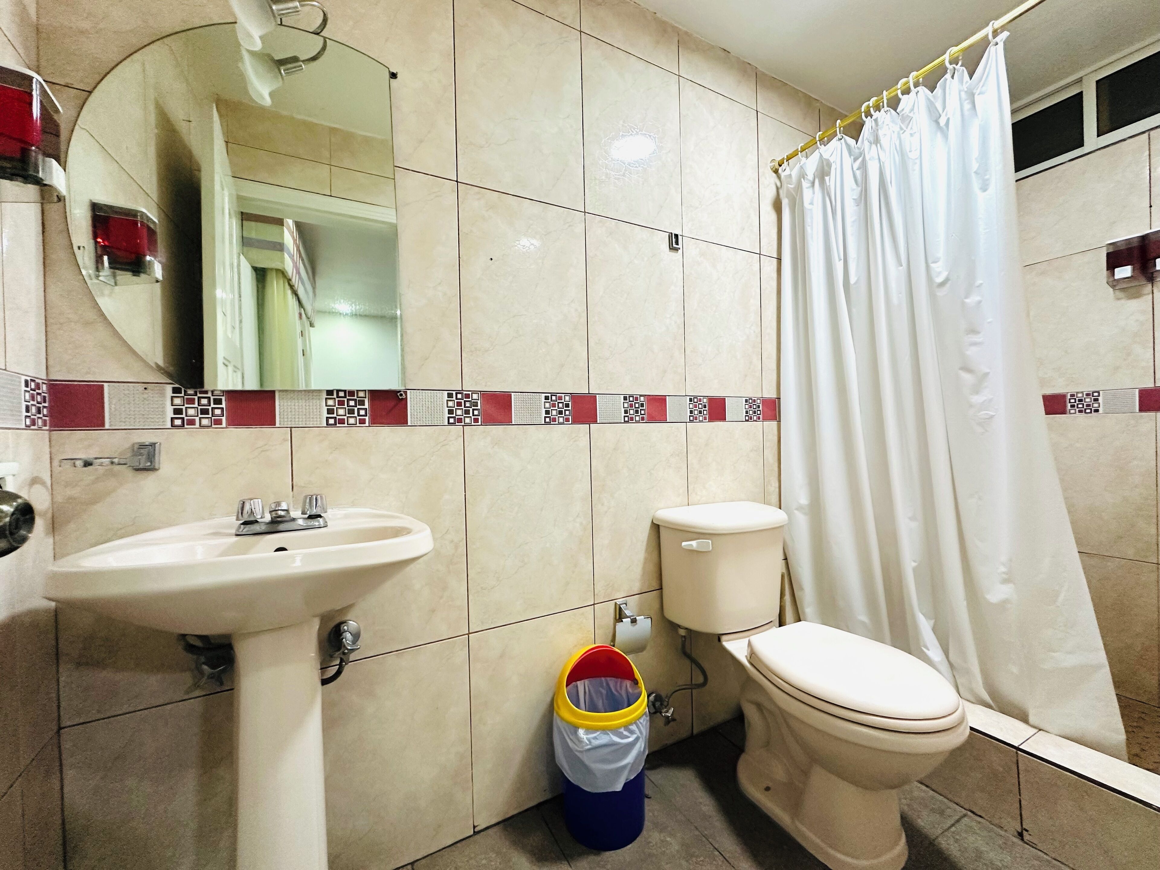A bathroom with a sink, toilet, and shower curtain.