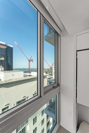A room with a large window overlooking a construction site with cranes.