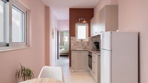Une cuisine moderne équipée d’un réfrigérateur, d’un évier et d’un plan de travail. On y trouve également un coin repas avec une table et des chaises.