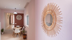 Un intérieur moderne avec une table ronde, des chaises, une horloge et un miroir mural original.
