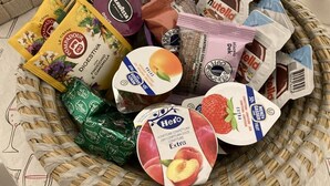 Una cesta con diversos alimentos, incluyendo bocadillos envasados y productos lácteos.
