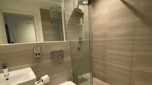 A modern bathroom with a glass shower enclosure, a sink, and a toilet. - Cocoa Suites-2 Bed-city Centre-pets-parking (York)