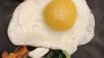 Ein Teller mit Spiegelei, Gemüse und Käse.