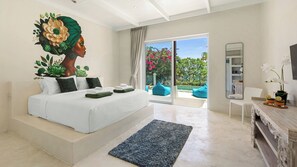 A modern bedroom with a large bed, a view of the outdoors, and a dining area with a mirror and flowers.