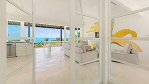 Un interior moderno con cocina, comedor y sala de estar con vista al océano.