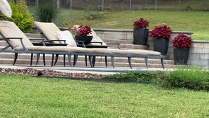 A poolside area with lounge chairs and potted plants. - Perfect Poolhouse (Linden)