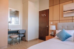 Relax in a stylish room with a large bed, nightstand, and comfortable seating area.