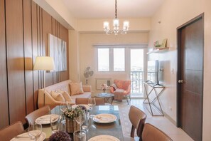 Relax in this stylish living room with a large window, flat-screen TV, and comfortable sofa.