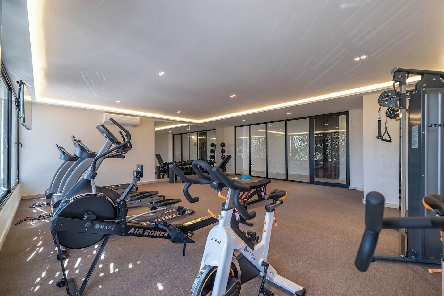 A gym with stationary bikes, treadmills, and weight machines.