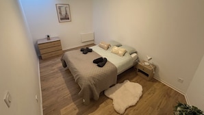 A bedroom with a bed, bedside table, lamp, and a framed picture on the wall. - 2chambres • 6 people - Near beach / cap blanc nez (Calais)