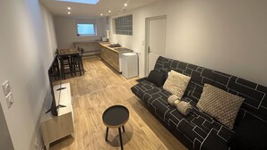 A modern apartment with a dining area, kitchenette, and a sofa with patterned cushions. - 2chambres • 6 people - Near beach / cap blanc nez (Calais)