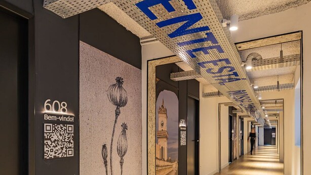 A hallway with a QR code, a door labeled '608,' and a large 'GENEVE' sign on the ceiling.