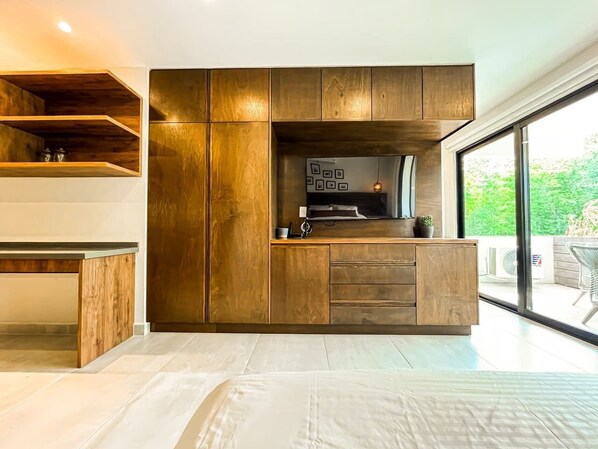 A modern kitchen with wooden cabinetry and a built-in microwave.
