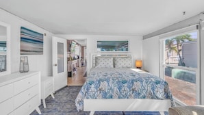A bedroom with a bed, a nightstand, a window with blinds, and a view of the outside. - On Island Time! HotTub-Water View (Marathon)