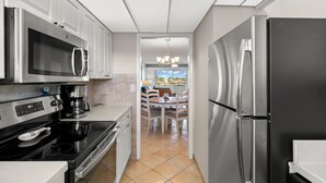 Une cuisine moderne dotée d’appareils électroménagers en acier inoxydable, un coin repas avec vue et un lustre.