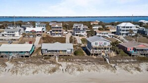 A coastal residential area with houses, some with beachfront access, and a sandy beach in the foreground. - Just For The Halibut 
Ocean Front Stay
Pet-Friendly (Emerald Isle)