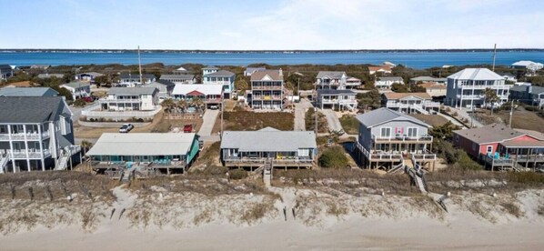 A coastal residential area with houses, some with beachfront access, and a sandy beach in the foreground. - Just For The Halibut
Ocean Front Stay
Pet-Friendly (Emerald Isle)