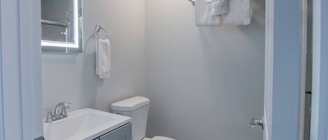 A bathroom with a white sink, toilet, and towel rack.