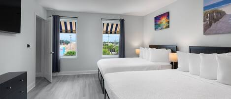 A hotel room with two beds, a TV, a window with curtains, and a painting on the wall.