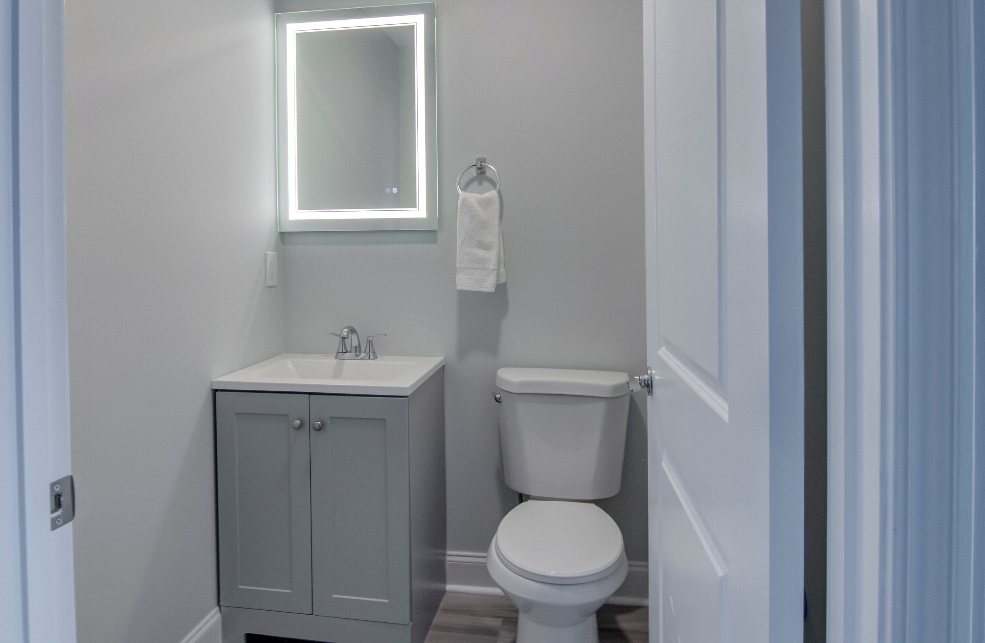 Un baño pequeño con inodoro, lavamanos y espejo.