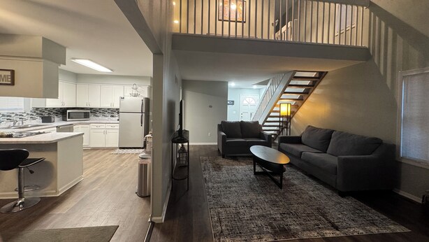 Un appartement moderne comprenant une cuisine, un salon et un escalier menant à une mezzanine.