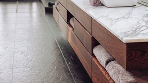 Une salle de bain moderne avec un comptoir en marbre, des meubles en bois et un grand miroir.