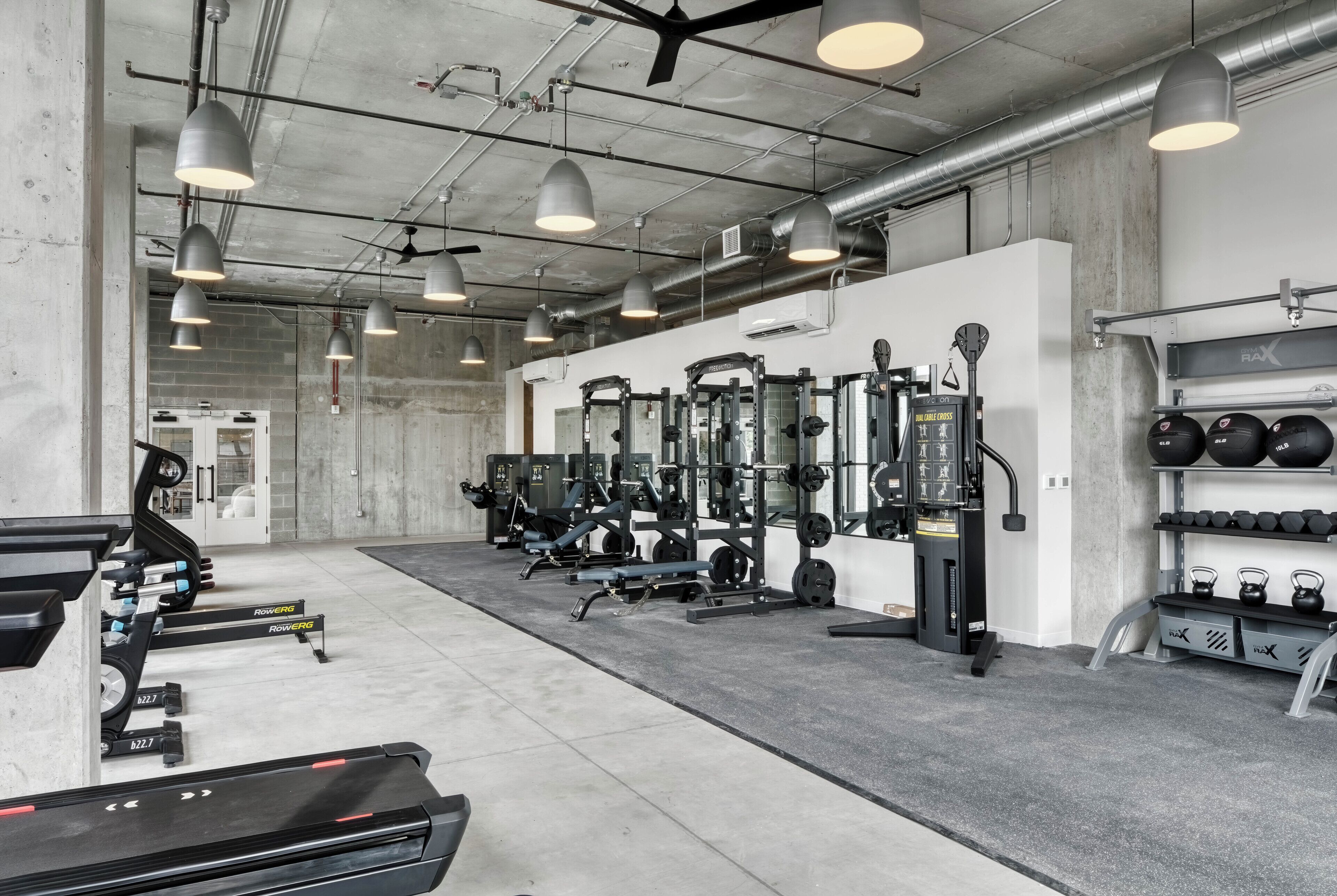 A gym with weightlifting equipment, treadmills, and dumbbells.