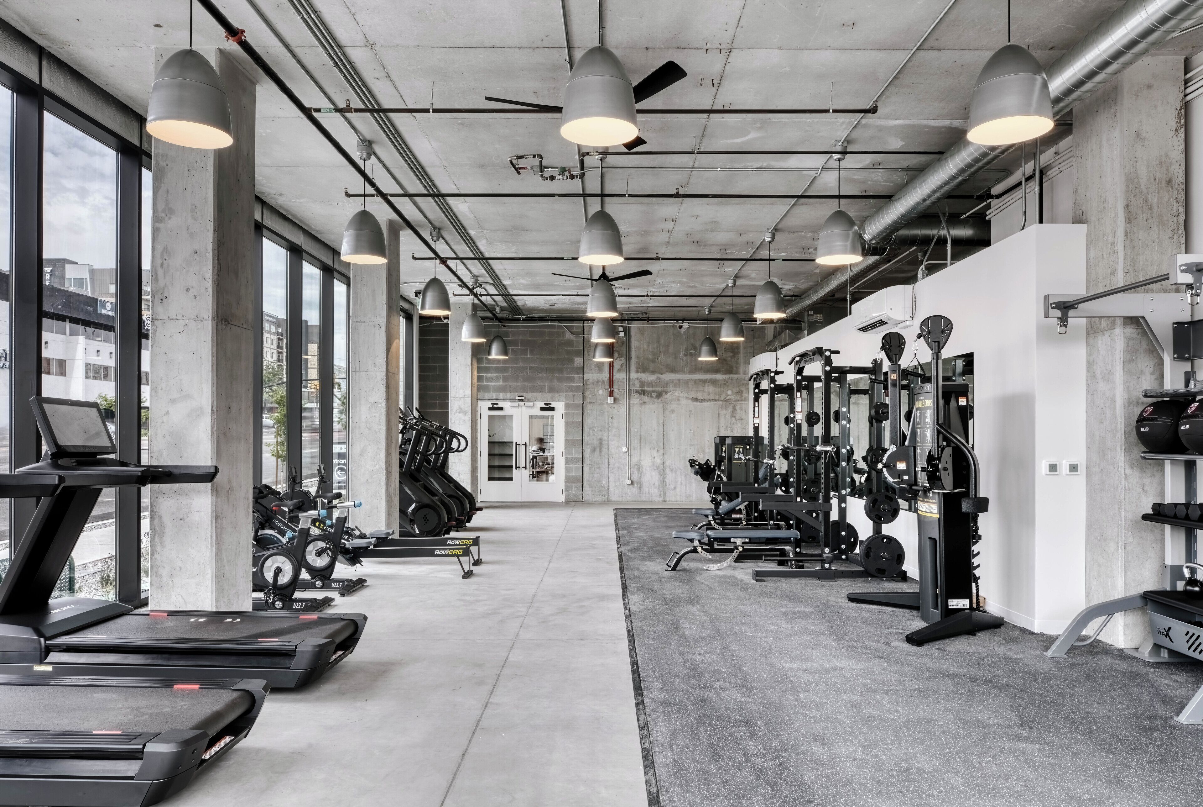 A gym with treadmills, elliptical machines, and weightlifting equipment.