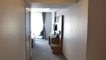 Una habitación de hotel moderna con una cama, un escritorio, una silla y un televisor.
