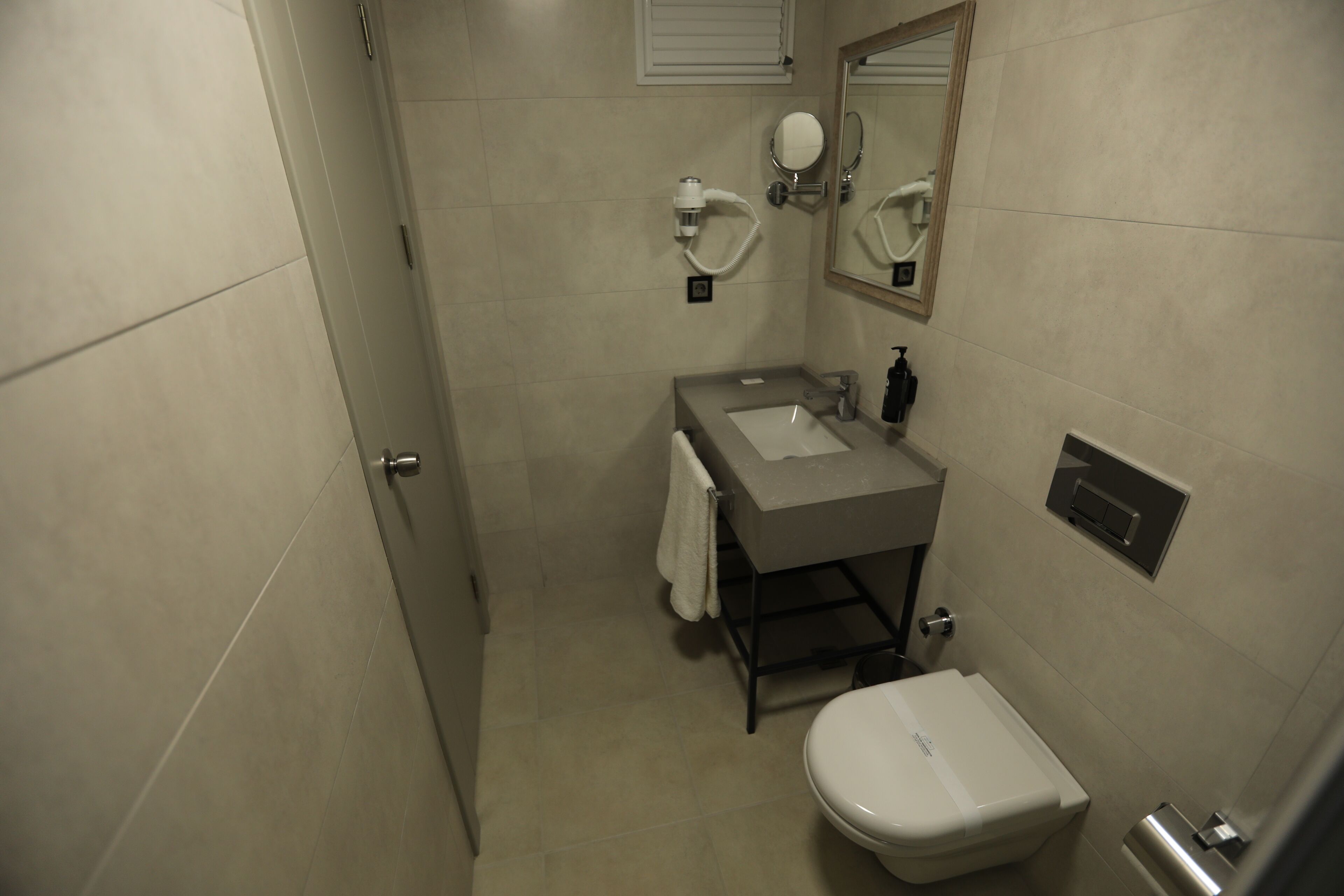 Un baño pequeño con lavamanos, espejo e inodoro.